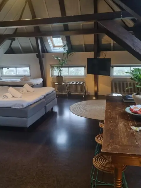 Ruime superior kamer met eettafel, keuken en houten balken