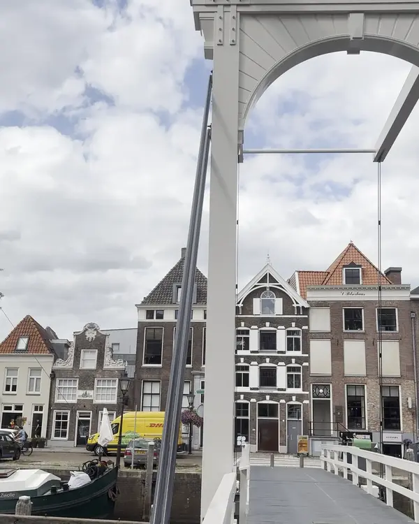 Witte ophaalbrug over de stadsgracht met grachtenpanden